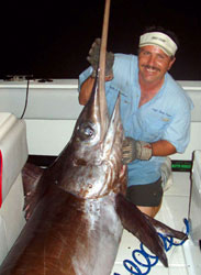 A happy guest with a broadbill swordfish